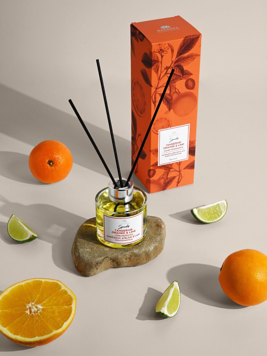Magrada Organic Cosmetics citrus home fragrance diffuser with orange scent and black reeds on stone