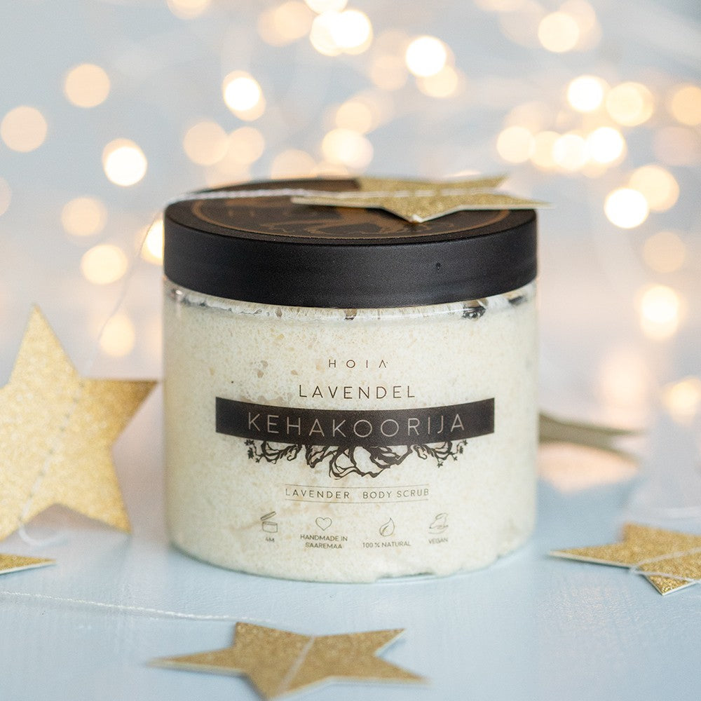 HOIA lavender body scrub in a clear jar with black lid surrounded by gold star decorations