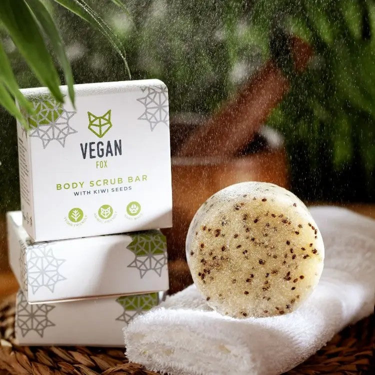 Vegan Fox kiwi seed body scrub bar with natural exfoliating seeds displayed on white towel with product boxes