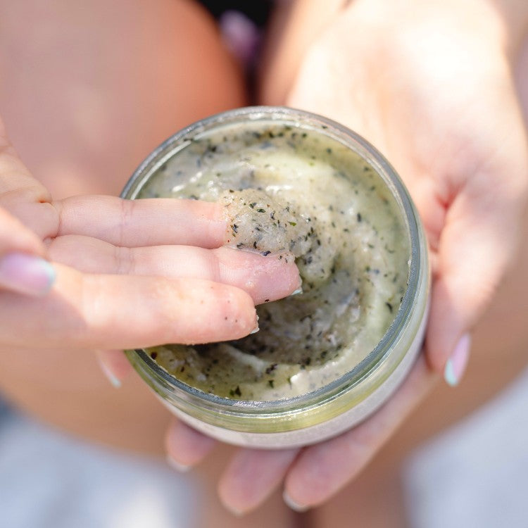 Vegan Fox peppermint body scrub in jar with person applying exfoliating scrub on fingers