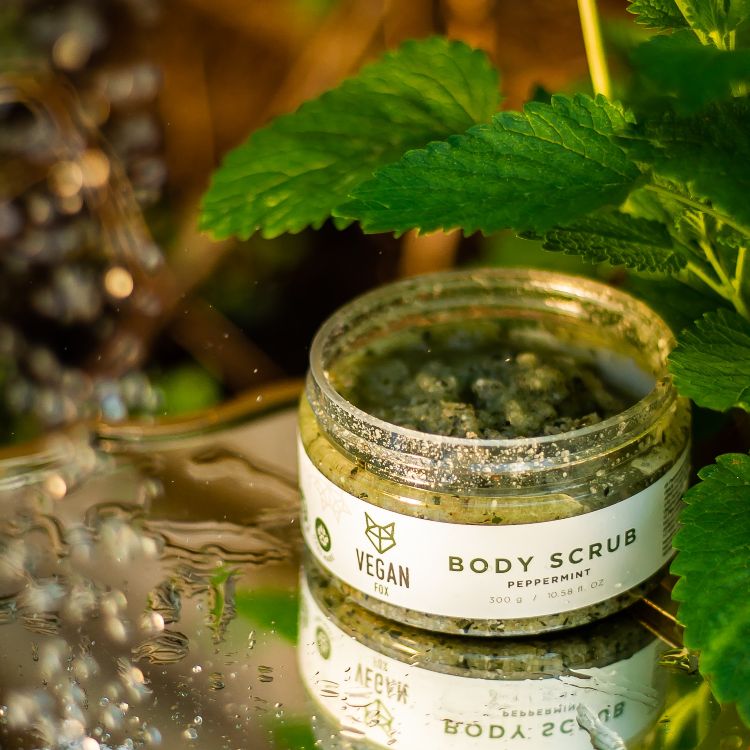 Vegan Fox peppermint body scrub jar with natural green scrub and fresh mint leaves nearby